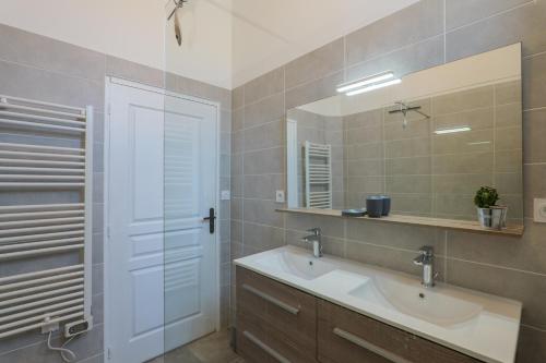 a bathroom with a sink and a mirror at T4 Cosy - Château - Wifi in Aubenas