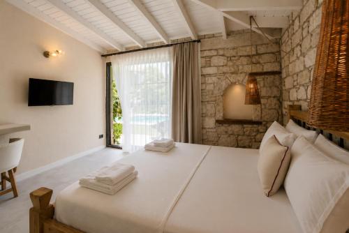 a bedroom with a large white bed and a window at Moranka by ALS ALAÇATI in Alaçatı