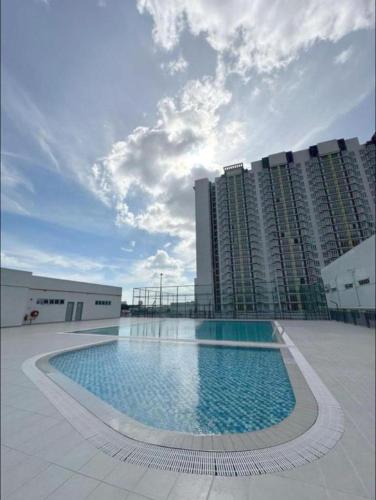 a large swimming pool in front of a large building at Aariz Homestay in Malacca