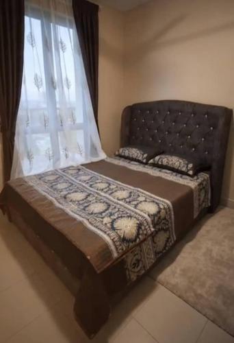 a bed sitting in a room with a window at Aariz Homestay in Malacca