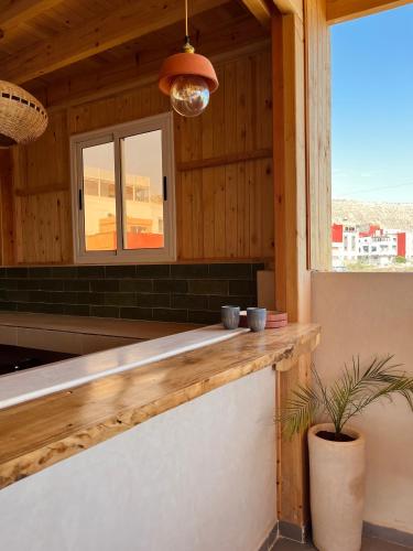 a kitchen with a wooden counter and a window at Little Palm Camp in Imsouane