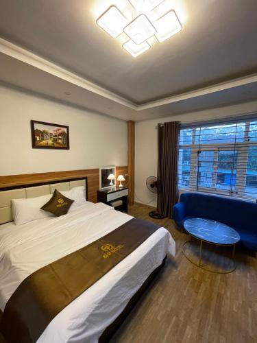 a bedroom with a large bed and a blue couch at G9 Home hotel in Hanoi