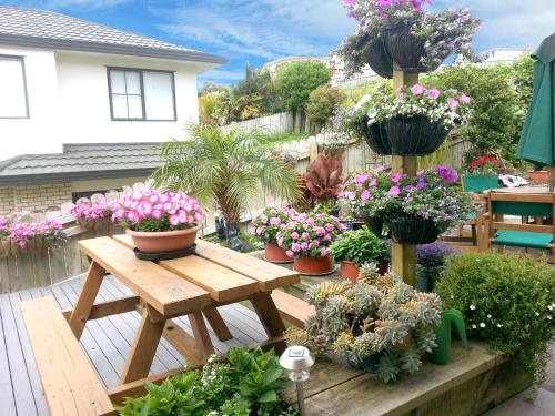 a garden with potted plants on a wooden table at Lush & Co Auckland Bed & Breakfast in Auckland