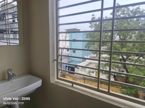 a bathroom with a window with a tub and a sink at SRIPADAVALLABHANIVAS2 pithapuram in Pithāpuram