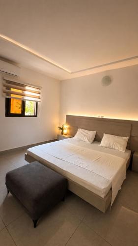 a bedroom with a large white bed and a window at Djess in Abidjan