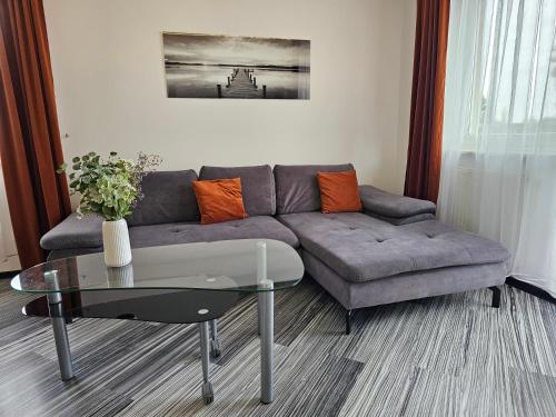 a living room with a couch and a glass table at Apartament SPACE & SUN z wewnętrzym ogrodzonym parkingiem in Toruń