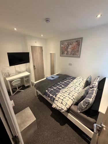 a bedroom with a bed and a desk and a television at Large 6 Bed 6 Bathroom House - Ideal For Families, Large Groups, Contractors & Business Travellers in Watford