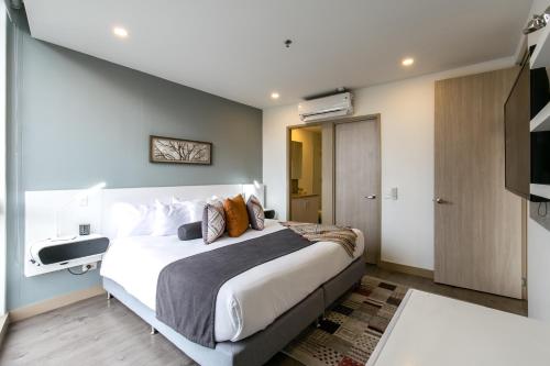 a bedroom with a large bed and a flat screen tv at Soul Lifestyle Hotel in Medellín