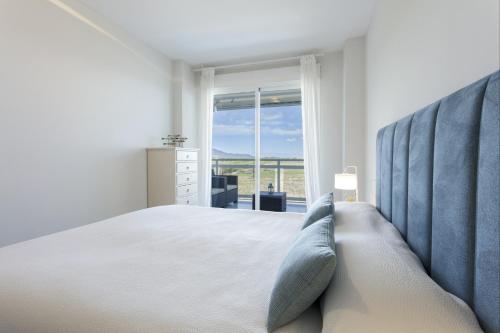 a bedroom with a large bed and a large window at AG Aiguablava Vista Mar in Playa de Gandia