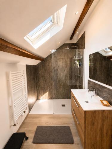 a bathroom with a shower and a sink and a window at Gîte Caussenard rénové in Le Massegros
