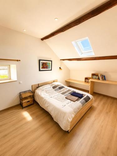 a bedroom with a large bed in a attic at Gîte Caussenard rénové in Le Massegros