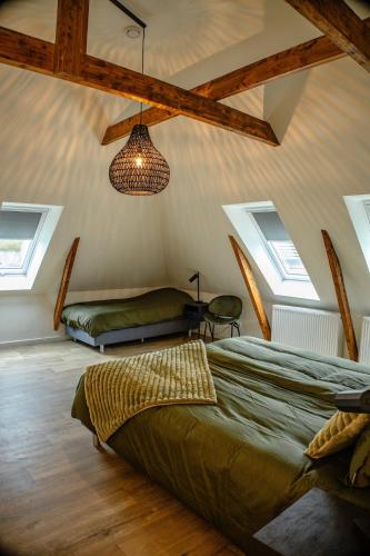 a bedroom with a bed and a ceiling with windows at BrinkZicht vakantieverblijf in Peize