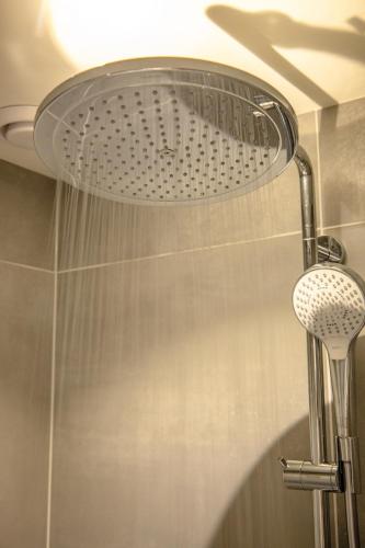 a shower with a shower head in a bathroom at BrinkZicht vakantieverblijf in Peize