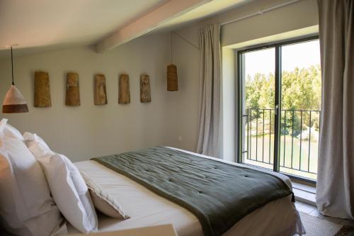 a bedroom with a bed and a large window at Les Terrasses de Bélarga - Maison d'hôtes - Piscine et Jacuzzi in Bélarga