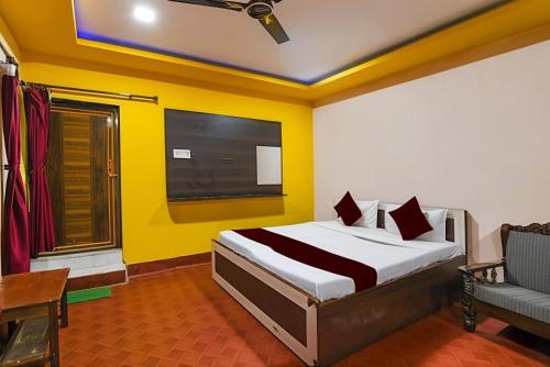 a bedroom with a bed and a tv and a couch at Hotel Ashirbad I comfort Near Railway Station in Bhubaneshwar