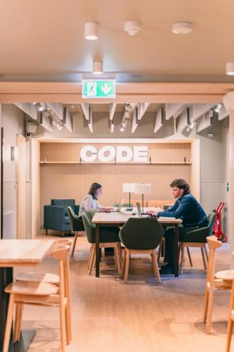 two people sitting at tables in a restaurant at CODE - The Court, Edinburgh in Edinburgh