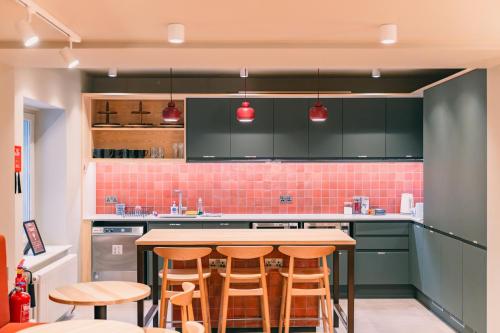 a kitchen with green cabinets and a table with stools at CODE - The Court, Edinburgh in Edinburgh