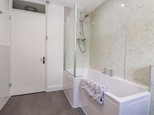 a white bathroom with a tub and a shower at The Granary in York
