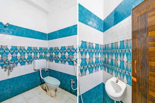 two pictures of a bathroom with blue and white tiles at Hotel Ashirbad I comfort Near Railway Station in Bhubaneshwar