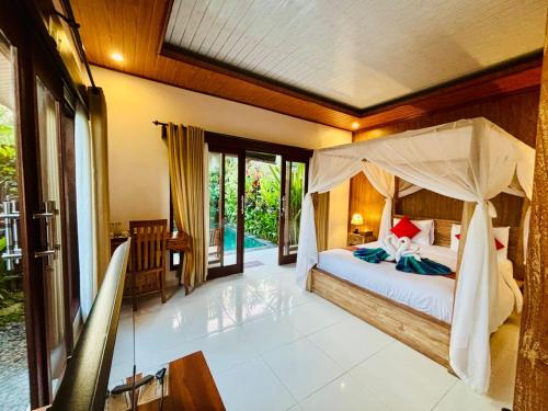 a bedroom with a bed with a canopy at pondok ubud nia cahya in Tegalalang