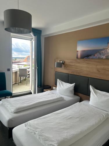 a hotel room with two beds and a window at Burghotel Homberg in Homberg