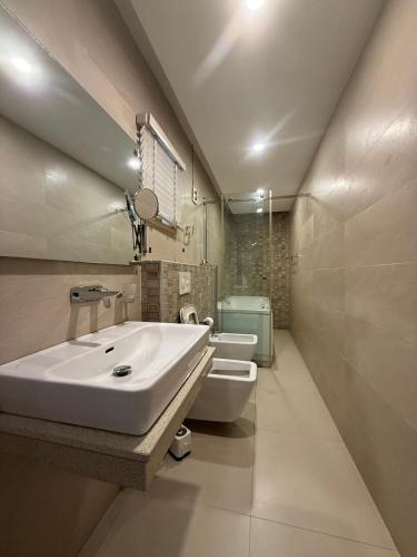 a white bathroom with a sink and a toilet at Catherine Villa in Lagos