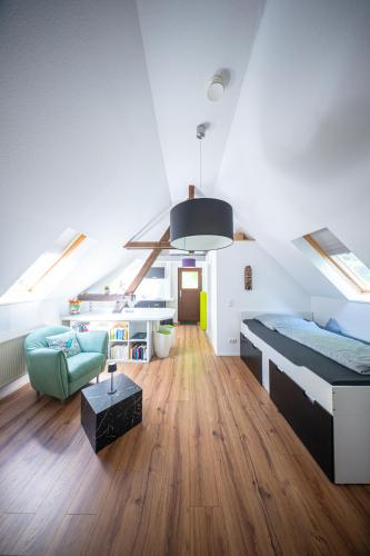 a loft bedroom with a bed and a couch and a table at Beim alten Forsthaus in Zella-Mehlis