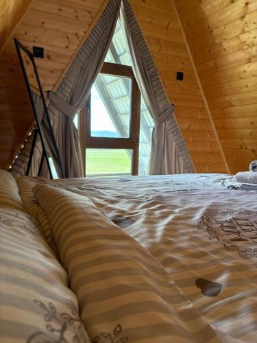 a large bed in a room with a window at Brvnare na Oku Zlatibor in Ocka Gora