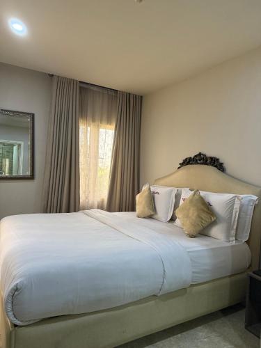 a large white bed in a bedroom with a window at Catherine Villa in Lagos