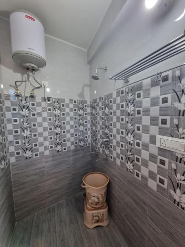 a bathroom with a toilet in a room with tiles at Hotel Rajinder Prasth in Dalhousie
