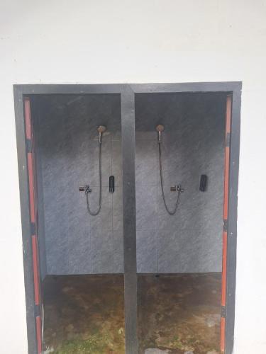 a bathroom with two shower stalls in a wall at Fat Monkey in Koh Rong Island