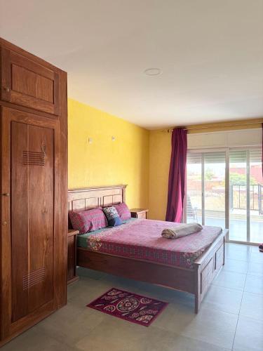 a bedroom with a bed and a wooden cabinet at Maison villa la faveur in Ngaparou