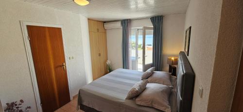 a bedroom with a bed with pillows and a window at Sunny house KIMI in Omiš