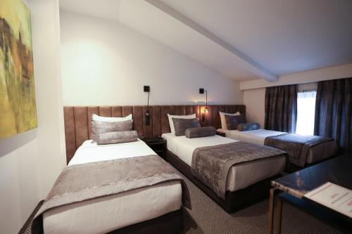 a hotel room with two beds and a window at Hotel Rubis in Ferizaj