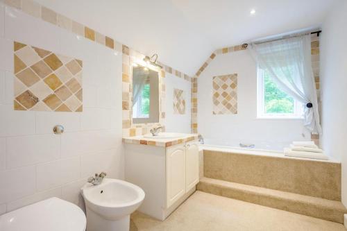 a bathroom with a toilet and a sink and a tub at 3 Bed in Ufford oc-sfmea in Ufford