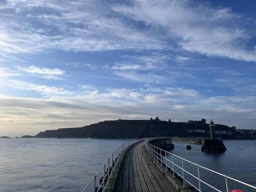 a bridge over a body of water with a hill at Whitby Old Town Stay, Sleeps 4, The Nest in Whitby