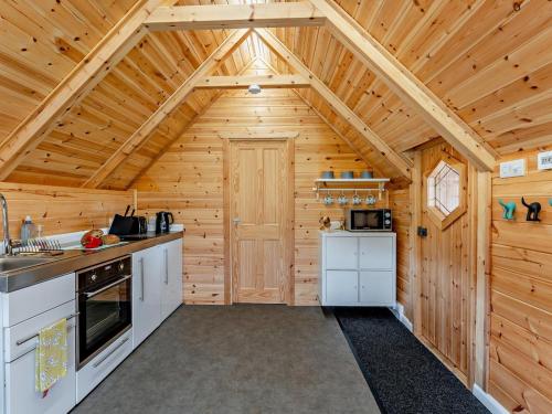a kitchen with white appliances in a wooden cabin at 1 Bed in Lanark oc-91248 in Libberton