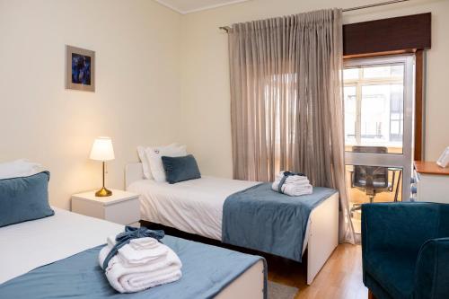 a hotel room with two beds and a window at RH Charming Apartment - D Nuno in Barcelos