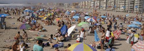 una gran multitud de personas en una playa con sombrillas en Yasna Gorigoitia, en La Serena