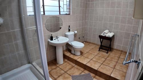 a bathroom with a toilet and a sink and a shower at Emmanuel Self-Catering Cottage in Thabazimbi