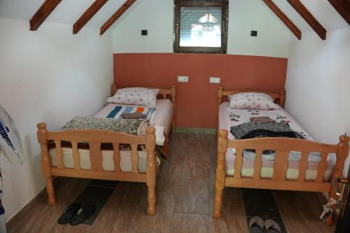 zwei Einzelbetten in einem kleinen Zimmer mit Fenster in der Unterkunft Kod Hamde in Jajce