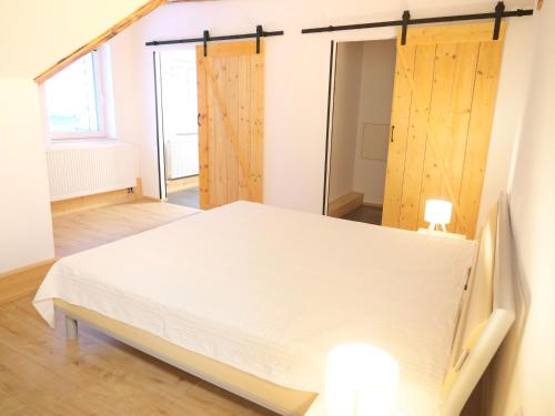 a bedroom with a bed and wooden sliding doors at Albsteig-Apartments Gruibingen in Gruibingen