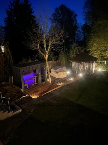 a backyard at night with a gazebo at POGO dom nad Narwią - 4 sypialnie, duża sauna, balia, pomost, plac zabaw in Pogorzelec