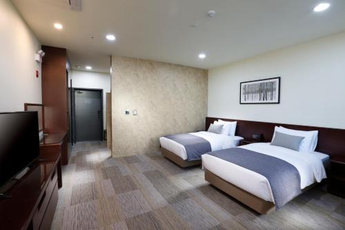 Postel nebo postele na pokoji v ubytování Geosung Hotel