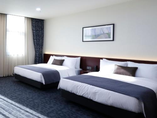 Postel nebo postele na pokoji v ubytování Geosung Hotel