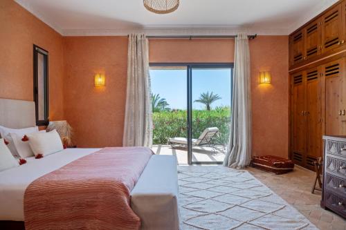 a bedroom with a bed and a balcony with a view at Bab Akoul Atlas - Boutique Hotel & Spa in Aït Namous