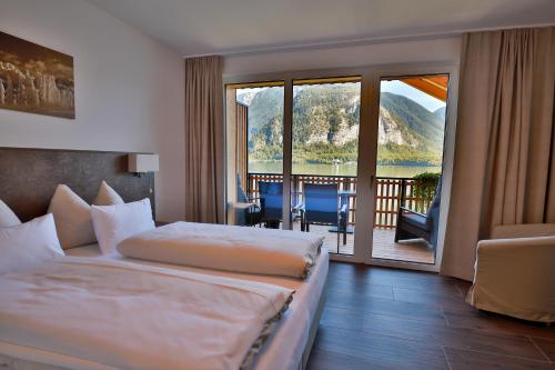 a hotel room with a bed and a balcony at Strand Hallstatt - Rooms only - Adults only in Hallstatt