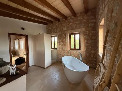 a large bathroom with a tub in a stone wall at Finca Latenéa in Islas Baleares