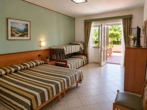 a hotel room with two beds and a balcony at Hotel Zilema in Guardia Piemontese Terme