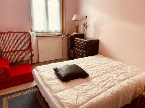 a bedroom with a bed with a black pillow on it at Les Volets Blancs in Étaples
